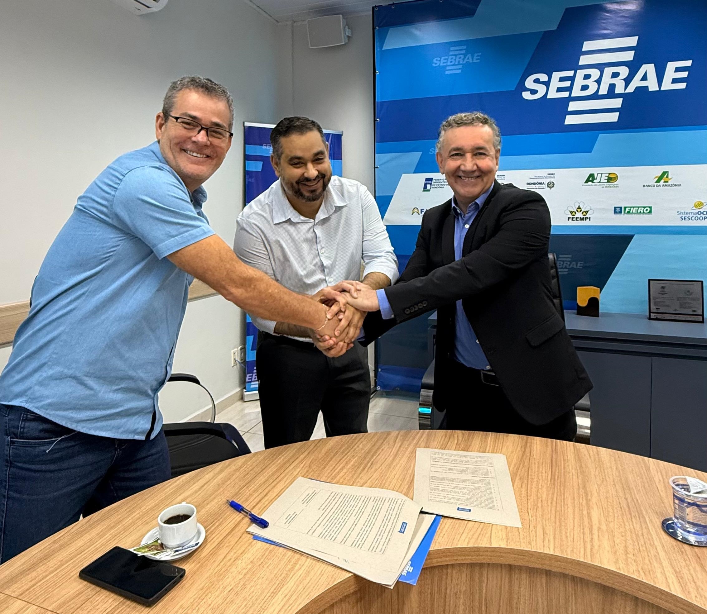 aldir Rothermel, diretor de Negócios do Sicoob; Giordani dos Santos Lima, secretário da Secretaria Municipal de Educação de Porto Velho; e Edson da Silva Lemos, diretor administrativo e financeiro do Sebrae em Rondônia, durante a assinatura do termo de adesão. | Fonte: Fernanda Nabôa.